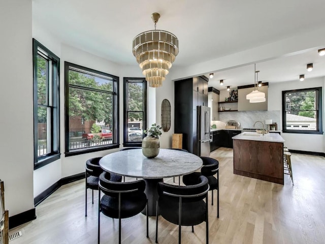 2457 N Talman Ave, Chicago, IL 60647 - dining space featuring light wood-style floors, a chandelier, and baseboards