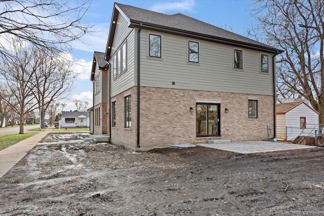 rear view of house featuring brick siding and a patio area