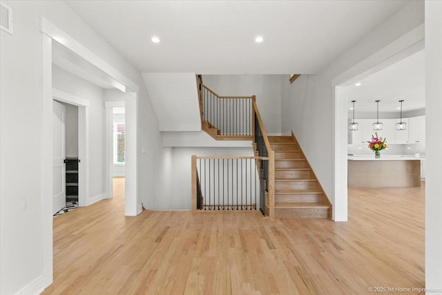 stairway with visible vents, recessed lighting, and wood finished floors