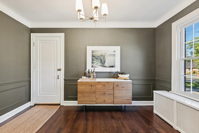 298 Dickens St, Northfield, IL 60093 - dining room with radiator, a chandelier, wood finished floors, a decorative wall, and wainscoting