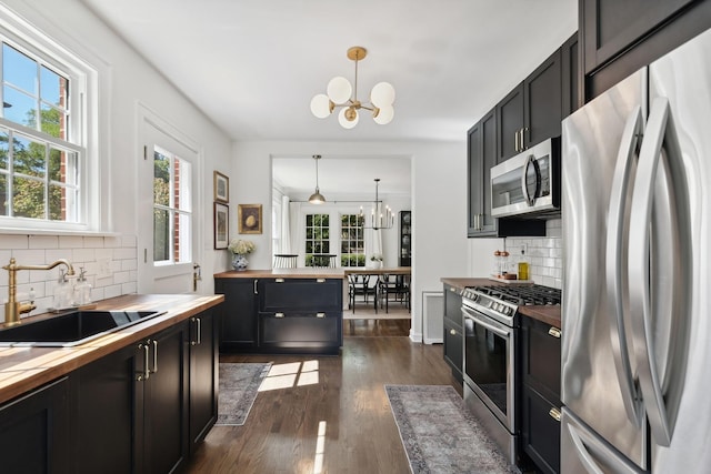 298 Dickens St, Northfield, IL 60093 - kitchen featuring wood counters, stainless steel appliances, a chandelier, and a sink