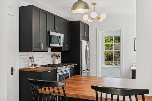 298 Dickens St, Northfield, IL 60093 - kitchen with wooden counters, appliances with stainless steel finishes, dark cabinets, tasteful backsplash, and a chandelier