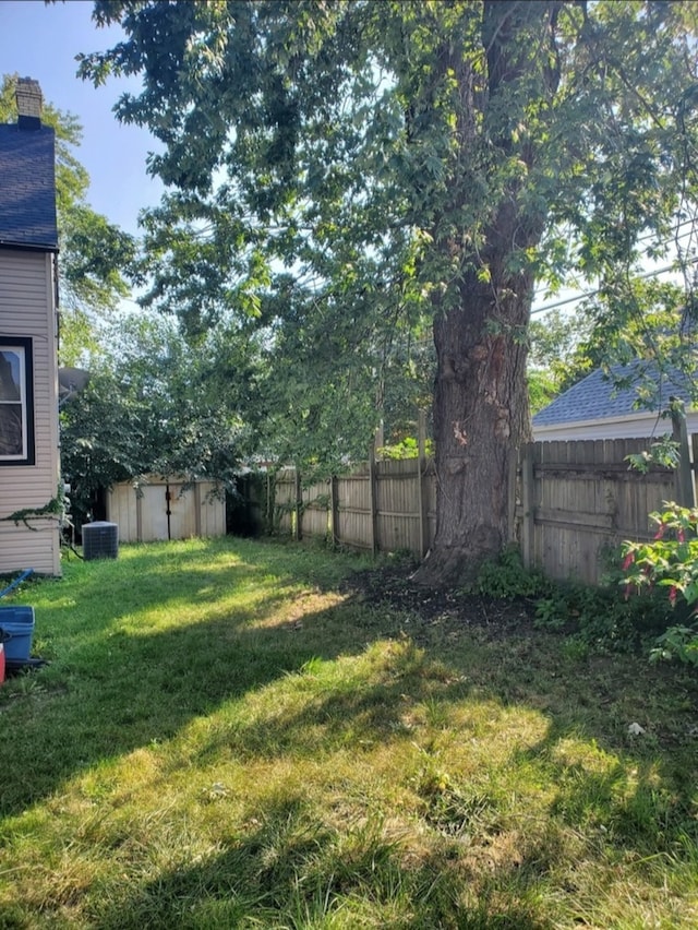 view of yard with central AC and a storage unit