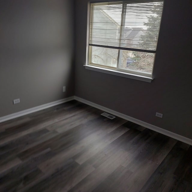 unfurnished room with dark wood-type flooring