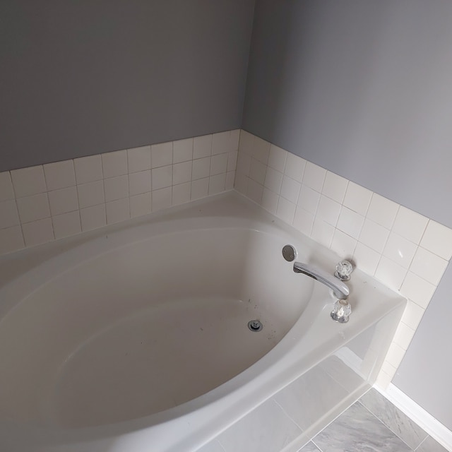 bathroom featuring tile floors and a washtub