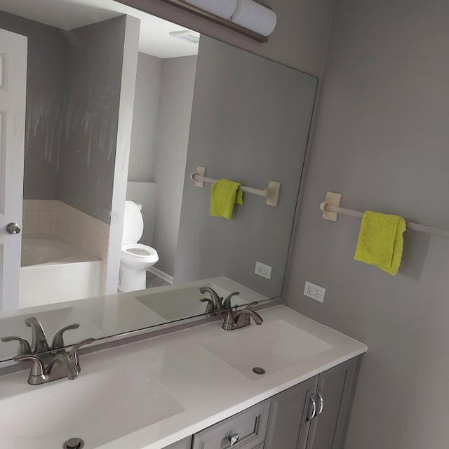 bathroom featuring toilet and double vanity