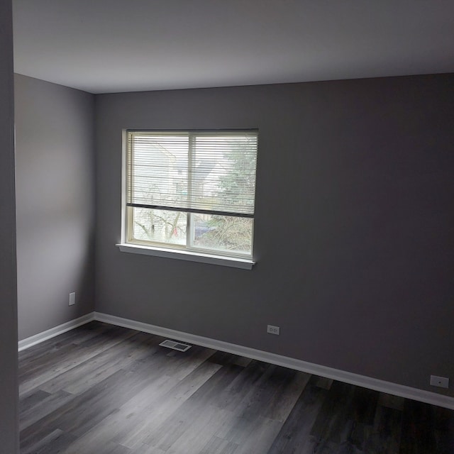 spare room featuring dark wood-type flooring