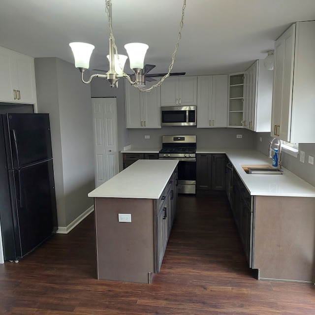 kitchen featuring pendant lighting, sink, appliances with stainless steel finishes, dark wood-type flooring, and an inviting chandelier