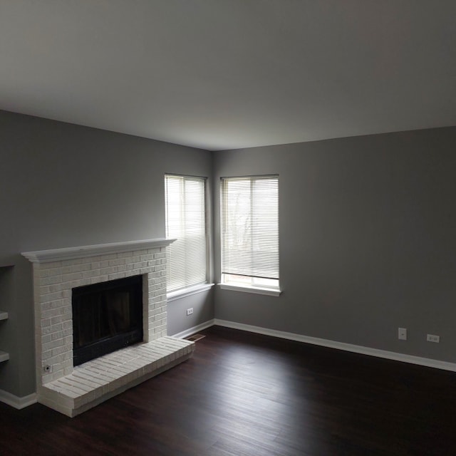 unfurnished living room featuring a fireplace and dark hardwood / wood-style floors