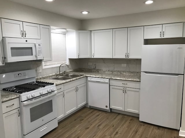 kitchen with white cabinetry, white appliances, sink, tasteful backsplash, and dark hardwood / wood-style flooring