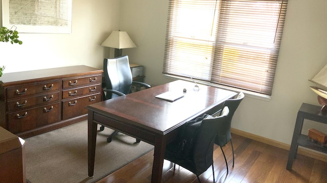 office featuring baseboards, a healthy amount of sunlight, and wood finished floors