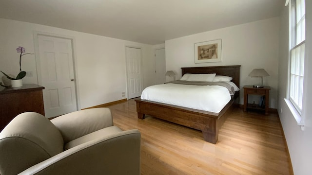 bedroom featuring light wood finished floors, a closet, and baseboards