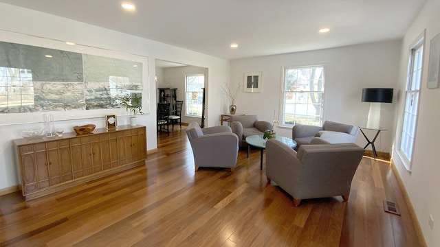 living room with recessed lighting, wood finished floors, and visible vents