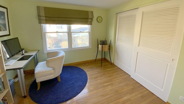 office area featuring light wood-type flooring, baseboards, and visible vents