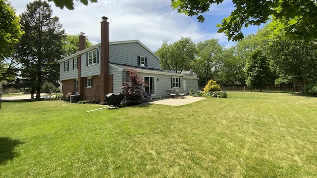 back of house featuring a patio area, a chimney, a yard, and fence