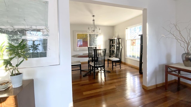 dining space featuring a notable chandelier, wood finished floors, and baseboards