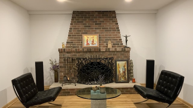 sitting room featuring a fireplace, wood finished floors, and baseboards