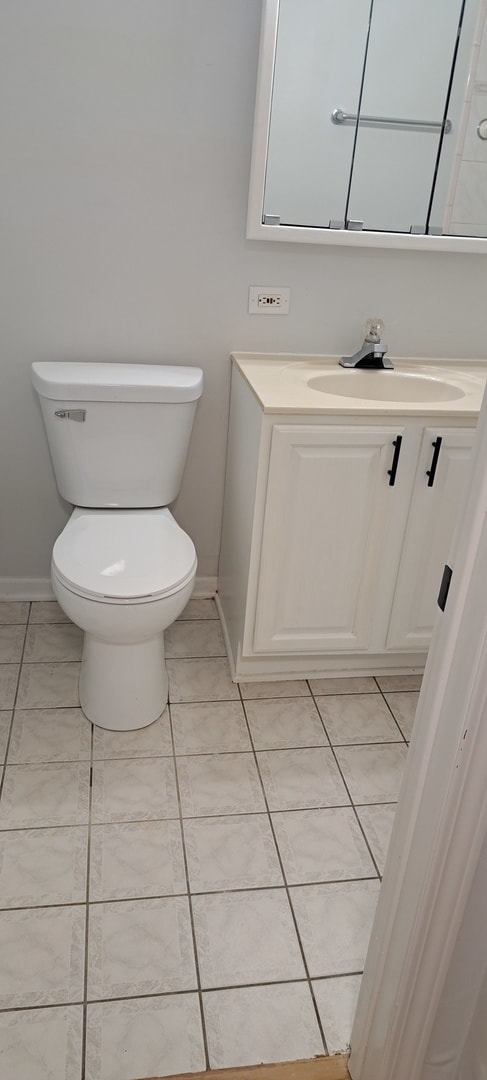 bathroom featuring vanity, tile flooring, and toilet