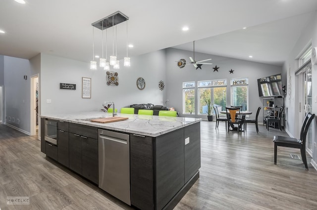 kitchen featuring light hardwood / wood-style floors, vaulted ceiling, a kitchen island, pendant lighting, and dark brown cabinetry