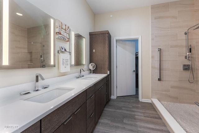 bathroom with vanity, tiled shower, and hardwood / wood-style floors