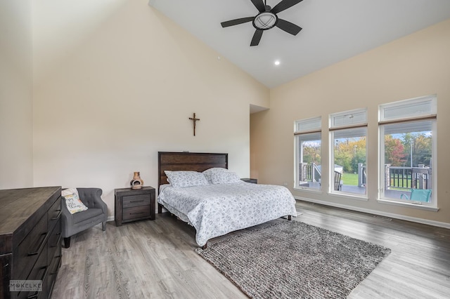 bedroom with ceiling fan, wood-type flooring, and high vaulted ceiling