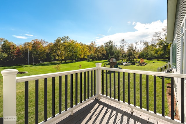 wooden deck featuring a playground and a yard