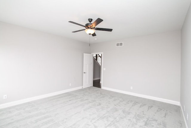 spare room featuring ceiling fan and light carpet