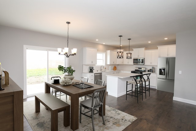 dining room featuring dark hardwood / wood-style flooring, an inviting chandelier, and sink