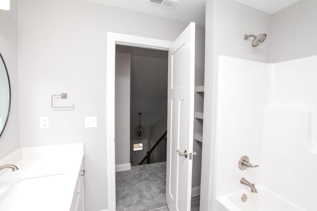 bathroom featuring washtub / shower combination, vanity, and tile patterned floors