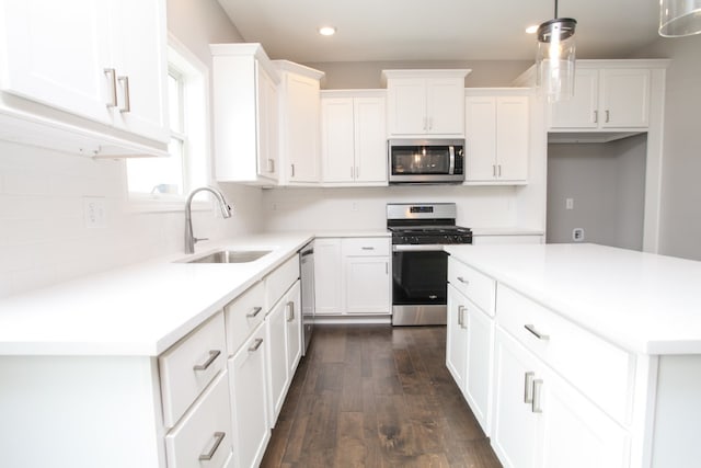 kitchen with sink, decorative light fixtures, appliances with stainless steel finishes, dark hardwood / wood-style floors, and white cabinetry