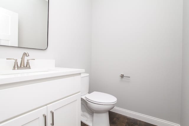 bathroom with hardwood / wood-style flooring, vanity, and toilet