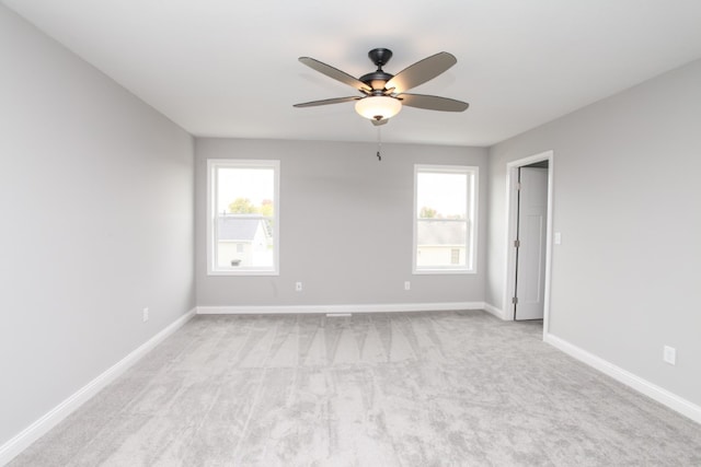 spare room with ceiling fan and light carpet