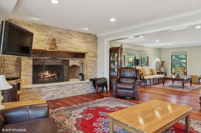 living room with hardwood / wood-style flooring, a fireplace, and ornamental molding