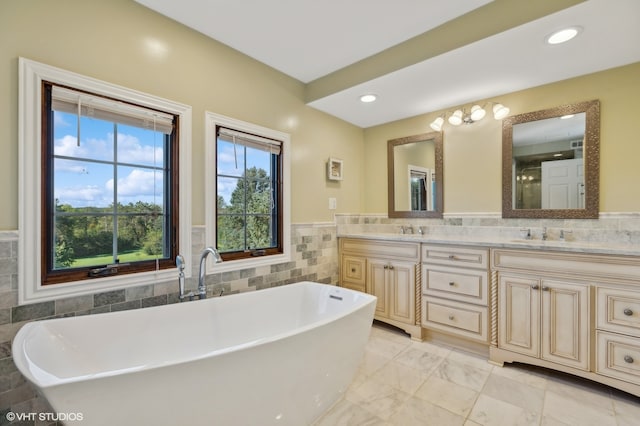 bathroom with tile walls, a bath, and vanity