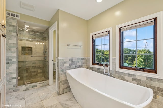 bathroom with plus walk in shower and tile walls