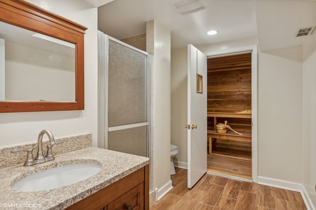 bathroom featuring walk in shower, vanity, and toilet