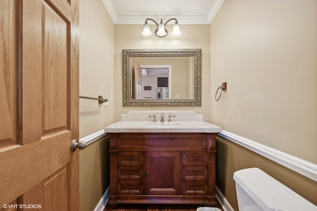 bathroom featuring vanity, crown molding, and toilet