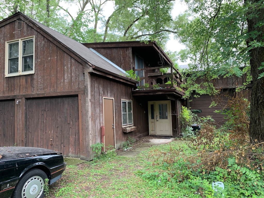 view of side of property featuring a balcony and a garage