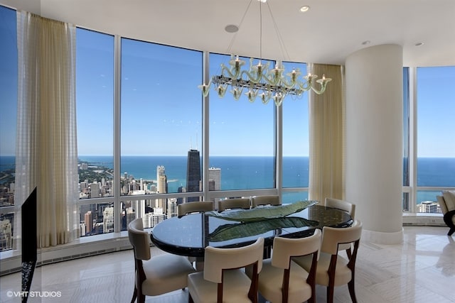 dining room featuring an inviting chandelier, a water view, and expansive windows