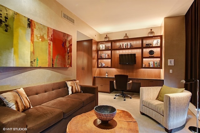 carpeted living room featuring built in desk