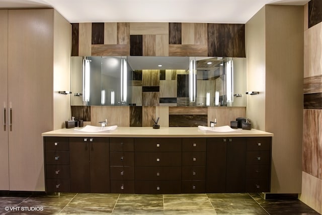 interior space featuring dark tile floors, dark brown cabinetry, and sink