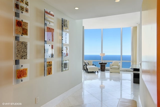 corridor with a water view and a wall of windows