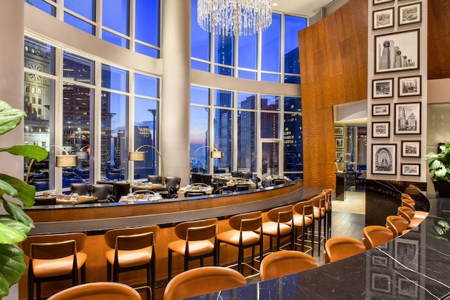 bar with a chandelier and a towering ceiling