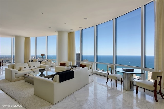 living room with a water view, a wall of windows, and a healthy amount of sunlight