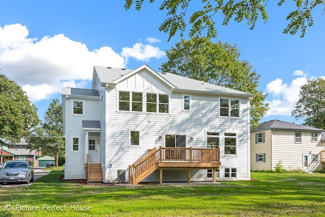 rear view of property with a lawn and a wooden deck