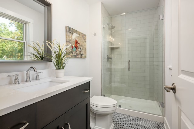 bathroom with oversized vanity, toilet, tile floors, and a shower with door