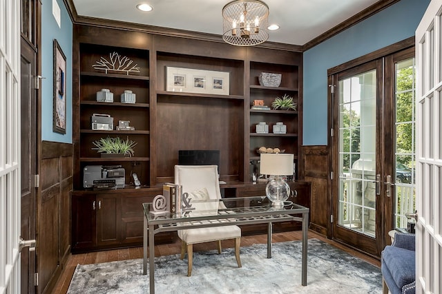 home office with french doors, crown molding, built in shelves, hardwood / wood-style flooring, and a chandelier