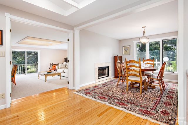 dining space featuring a raised ceiling and light hardwood / wood-style floors