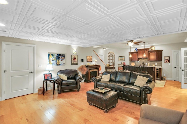 3001 E Stone Creek Blvd, Urbana, IL 61802 - living room with light wood-type flooring, an ornate ceiling, a ceiling fan, bar area, and wine cooler