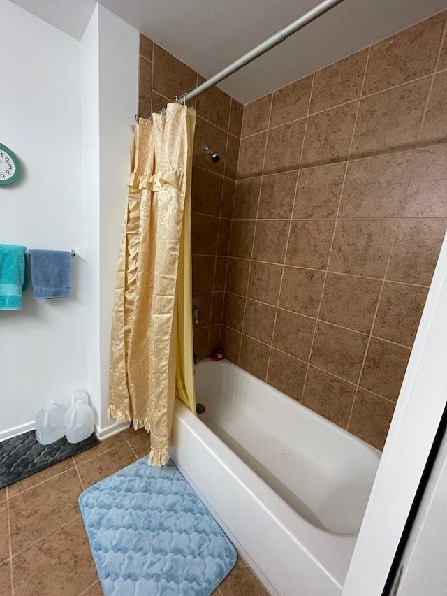 bathroom featuring shower / tub combo, tile patterned flooring, and baseboards
